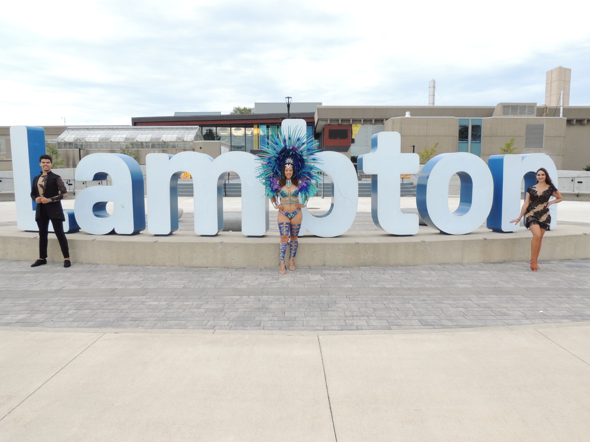 CaribeFest performers in front of Lambton college sign
